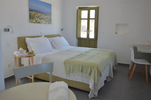 a bedroom with a bed and a table and a window at Vorina Ktismata in Amorgos