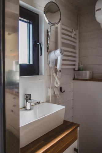 a bathroom with a white sink and a mirror at Heaven Reset Spa Luksusowy Glamping Jacuzzi w Naturze Blisko Warszawy in Korczew