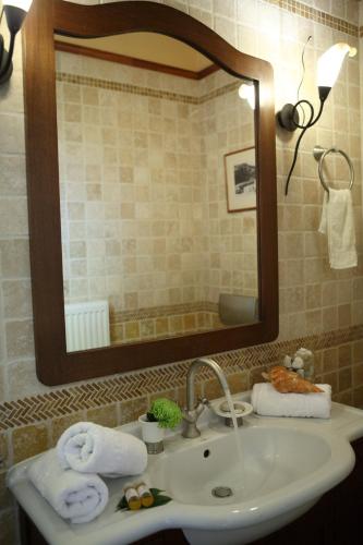 a bathroom with a sink and a mirror and towels at Miltiadis Farm in Lefkada Town