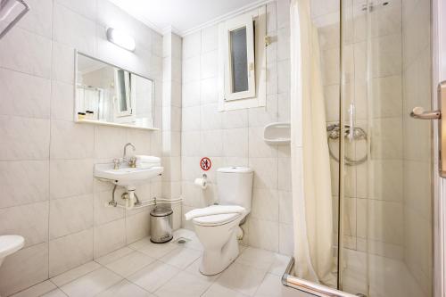a bathroom with a toilet and a sink and a shower at Athens City Hotel in Athens