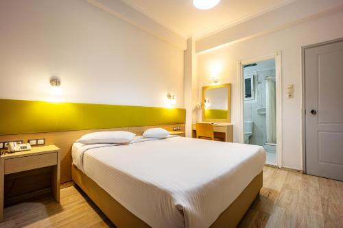 a bedroom with a large bed and a bathroom at Athens City Hotel in Athens