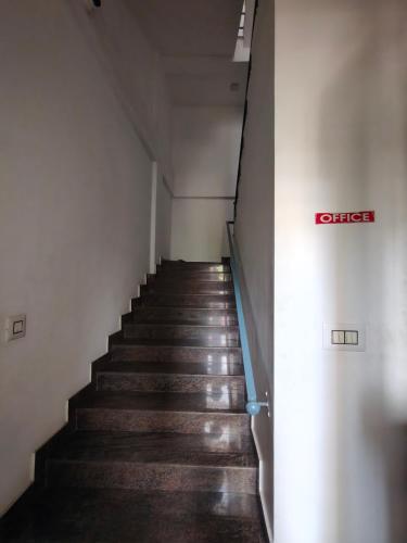 a staircase in a building with a sign on the wall at Queens INN in Kodungallūr