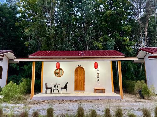 a small house with a table and chairs at สวนปาล์มการ์เด้นโฮม เชียงคาน Suanpalm Garden Home Changkhan in Chiang Khan
