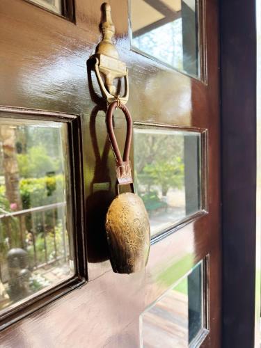 a vase hanging on a wall next to a window at Mor Pur - Royal Golf Course Stay in Manesar