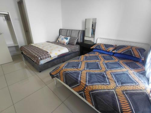two beds in a room with a bed and a couch at Aisyah Mutiara Bali Residence Melaka in Malacca
