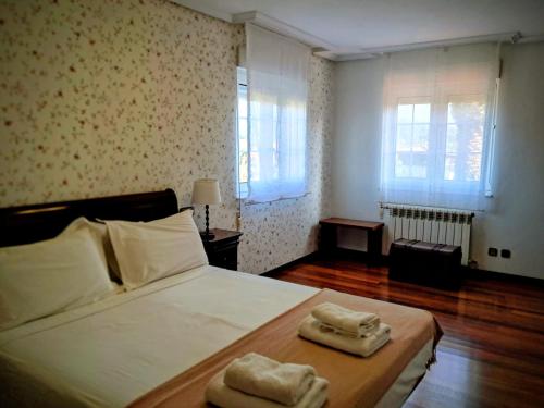Un dormitorio con una cama con dos toallas encima. en LA BUGANVILLA, en Gijón