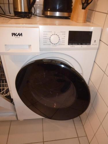 a white washing machine sitting in a kitchen at Ferienwohnungen am Rumbachtal in Mülheim an der Ruhr