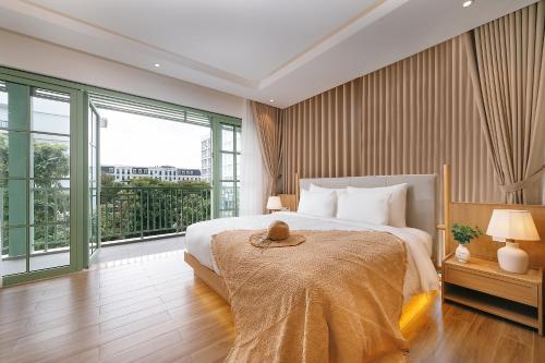 a bedroom with a large bed and a large window at La isla Apartments & Villas - Sea View & Fireworks Phu Quoc in Phu Quoc