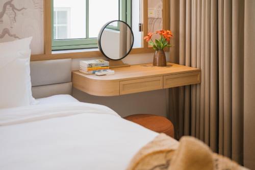 a bedroom with a table with a mirror and a bed at La isla Apartments & Villas - Sea View & Fireworks Phu Quoc in Phu Quoc