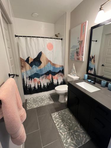 a bathroom with a toilet and a shower curtain at Deep Ellum Theatre Suite - The Black Collection in Dallas