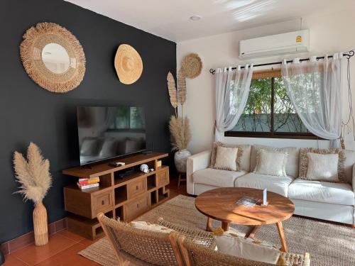 una sala de estar con un sofá y una mesa en Beachfront pool villa, en Kamala Beach