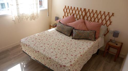 a bedroom with a bed with pink pillows at Piso Buenos Aires in Cee