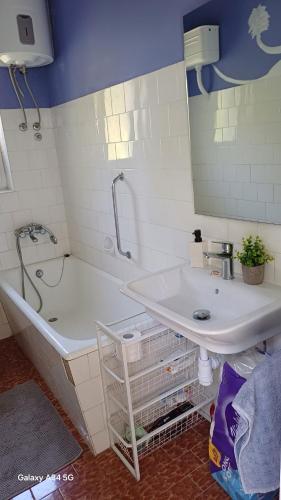 a bathroom with a sink and a tub and a mirror at Apartment Room with a view in Podgora