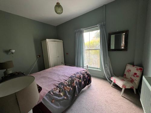 a bedroom with a bed and a chair and a window at Cilgwyn Manor in Myddfai