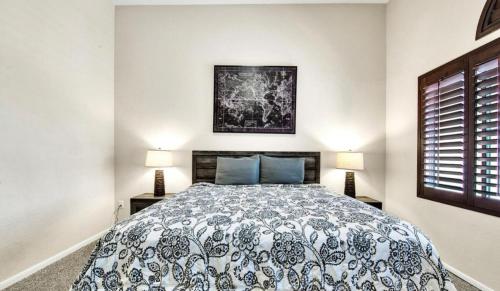 a bedroom with a bed with a blue and white comforter at TPC Golf Course North Scottsdale in Scottsdale