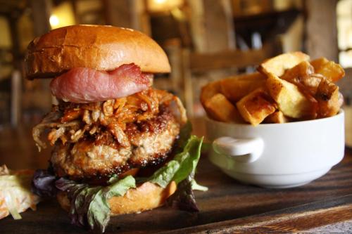 a hamburger and a bowl of french fries on a table at The Ram at Tivetshall in Tivetshall Saint Margaret