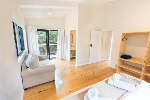 a living room with a white couch and wooden floors at 10d Mimosa - The Spot - by African Perfection in Jeffreys Bay