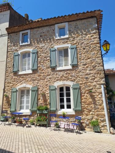 an old stone building with chairs and windows at La Retraite in Assignan