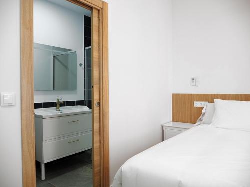 a bedroom with a bed and a sink and a mirror at Hotel Casbah in El Puig