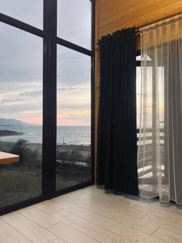 a room with a large window with a view of the ocean at Jargylchak-Sunrise in Kichi-Jargylchak