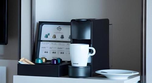 a coffee maker and a cup on a counter at Yokohama Royal Park Hotel in Yokohama