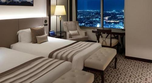 a hotel room with two beds and a desk at Yokohama Royal Park Hotel in Yokohama