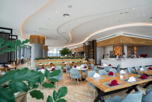 a rendering of a restaurant with tables and chairs at OceanView Alacarte Hạ Long in Ha Long