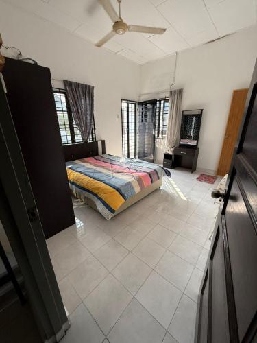 a bedroom with a bed in the middle of a room at RZ Semi D Homestay in Kelebang Besar