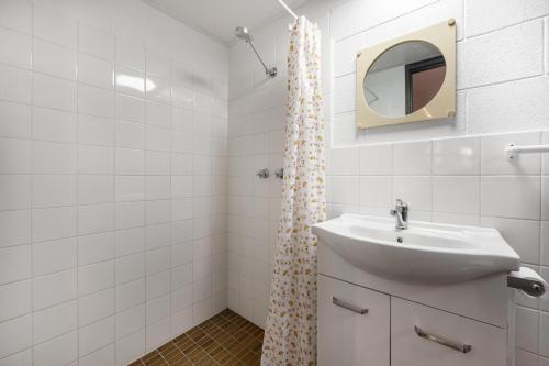 a white bathroom with a sink and a mirror at Kalganyi Holiday Park in Mount Gambier