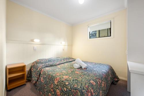 a hotel room with a bed and a window at Kalganyi Holiday Park in Mount Gambier