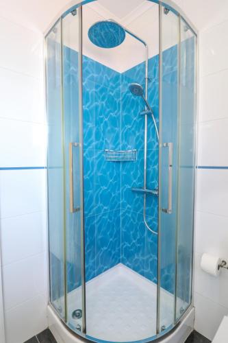 a shower in a bathroom with blue tiles at Parede Flats in Parede