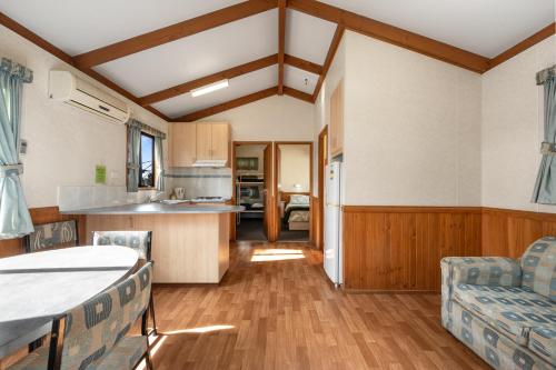 a kitchen and living room with a table and chairs at Kalganyi Holiday Park in Mount Gambier