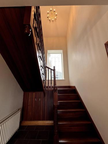 a staircase in a house with a chandelier at Stone House , Boyne Valley Views in Donore