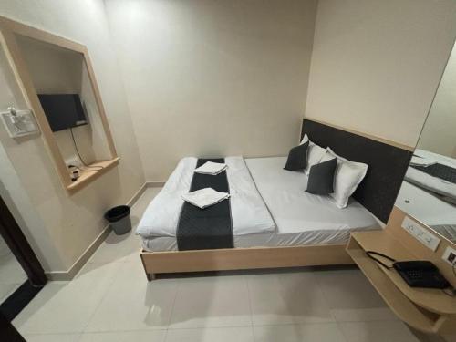a small bedroom with a bed with white sheets and pillows at Hotel Silver Moon-200 meter Jaipur Junction in Jaipur
