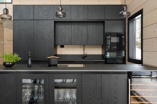 a kitchen with black cabinets and a black counter top at Serenity Levi - Hot Tub & Sauna in Levi