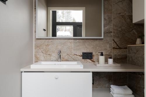a bathroom with a sink and a mirror at Serenity Levi - Hot Tub & Sauna in Levi