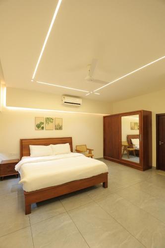 a bedroom with a large bed in a room at Kaayal Experience - Entire Home in Kozhikode in Kozhikode
