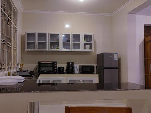 a kitchen with a counter top with a refrigerator at Spacious Beachfront Condo -AC - WiFi, Uroa Escape Zanzibar in Uroa