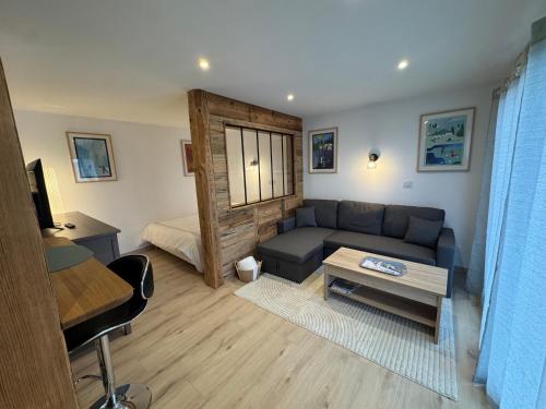 a living room with a couch and a bed at Petit cocon cosy entre lac et montagnes in Malbuisson