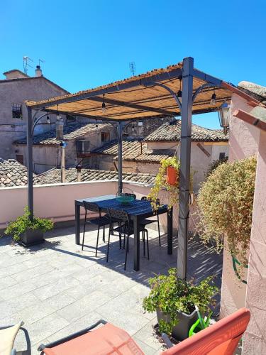 a patio with a table and a wooden pergola at Pink house in Fara in Sabina