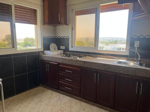 a kitchen with a sink and two windows at Appartements Armonía Sea View in Briech