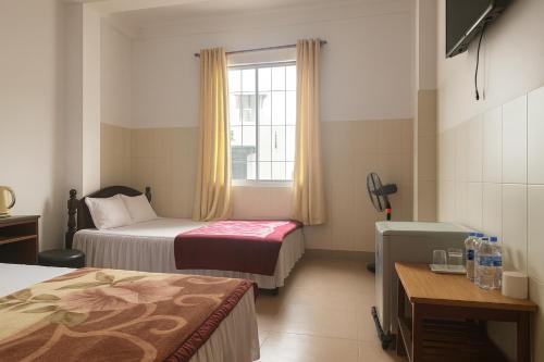 a hotel room with two beds and a window at Viet Ha Hotel in Da Lat