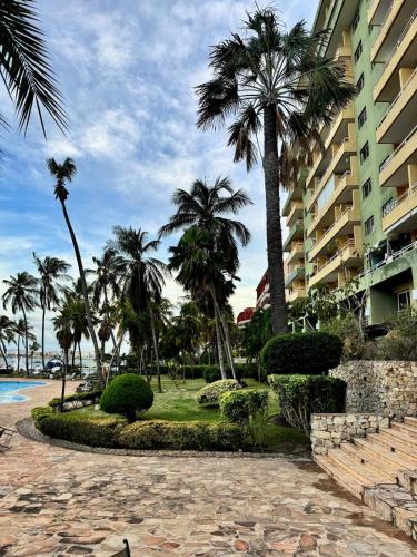 a resort with palm trees and a building at Premium Lecheria - Oceanfront, Pool & Relax in Morro de Barcelona