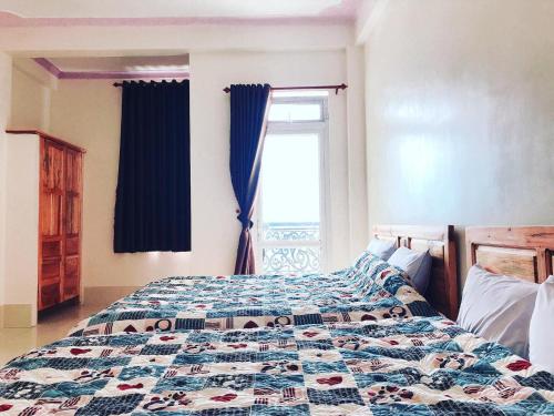 a bedroom with a bed with a quilt on it at Aloha farm in Namban