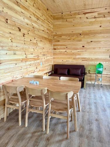 a wooden room with a wooden table and chairs at Aloha farm in Namban