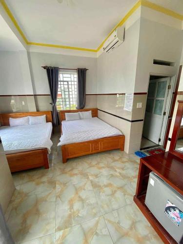 a bedroom with two beds and a tv in it at Nhà Nghỉ Cẩm Tiên 1 in Ha Tien