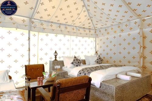 a bedroom with a bed and a table in a room at Khamma Ghani Resort with pool Luxury camp in Jaisalmer in Jaisalmer