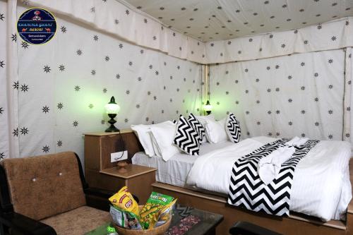 a bedroom with a bed with black and white pillows at Khamma Ghani Resort with pool Luxury camp in Jaisalmer in Jaisalmer