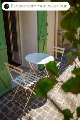 a table and two chairs in front of a door at Le Verdon, cozy et authentique in Gréoux-les-Bains