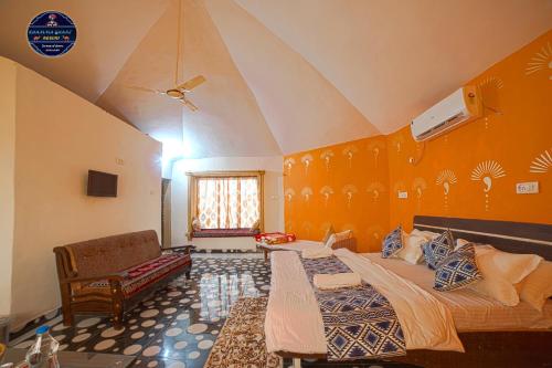 a bedroom with a large bed with an orange wall at Khamma Ghani Resort with pool Luxury camp in Jaisalmer in Jaisalmer